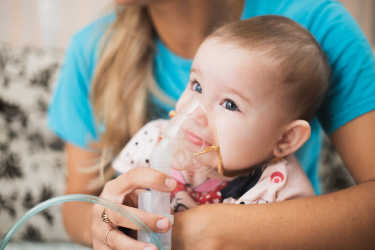 Mom makes inhalation of the child, holding hands